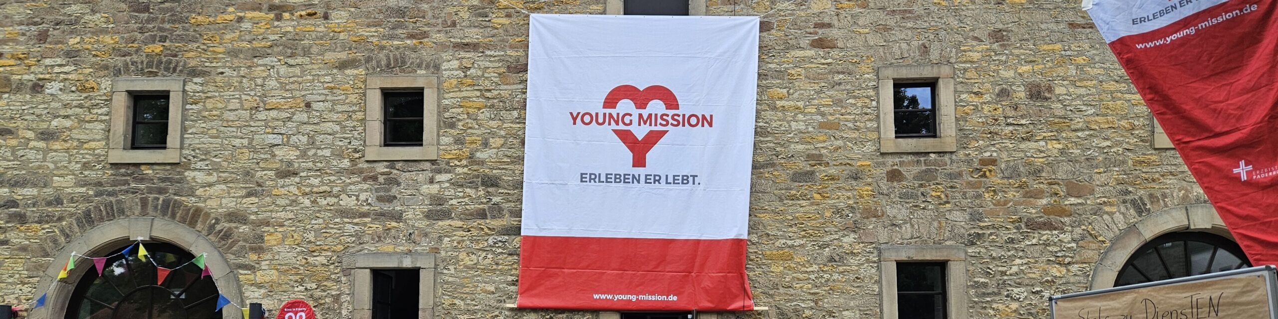 Die Hauswand eines Gebäudes mit dem Banner von Young Mission.